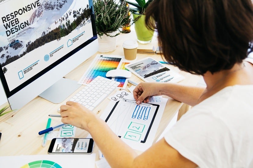 Woman working on computer and paper in front of it